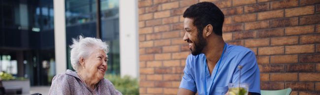 Caregiver having breakfast with his client at cafe.