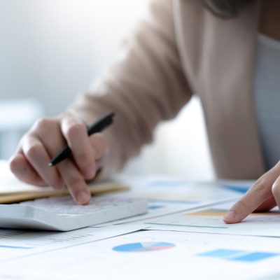 Businesswoman accountant working audit and calculating expense financial data on graph documents, doing finance in workplace. Businesswoman accountant working audit and calculating expense financial data on graph documents, doing finance in workplace..