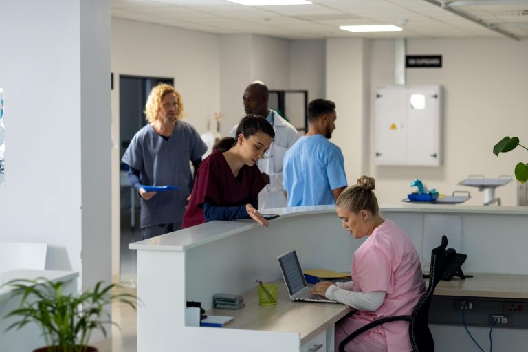 diverse-doctors-talking-at-reception-desk-at-hospi-2025-04-03-16-32-07-utc-min Aged care compliance tools | VCare Software