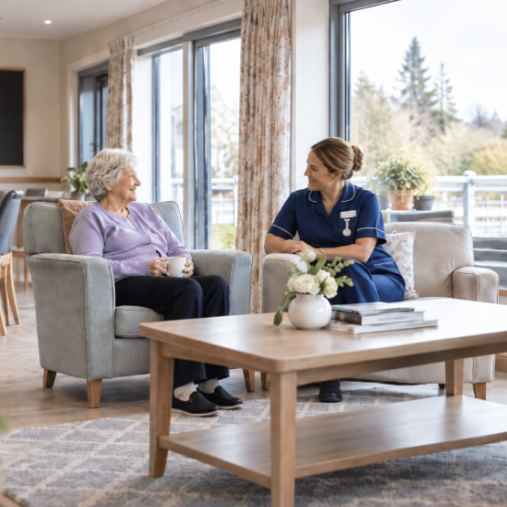 Nurse sitting with resident in a rest home environment
