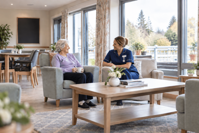 Nurse sitting with resident in a rest home environment